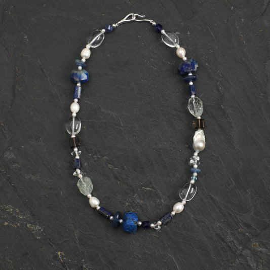 Lapis lazuli necklace with blue beads, pearl accents, and clear crystal charms