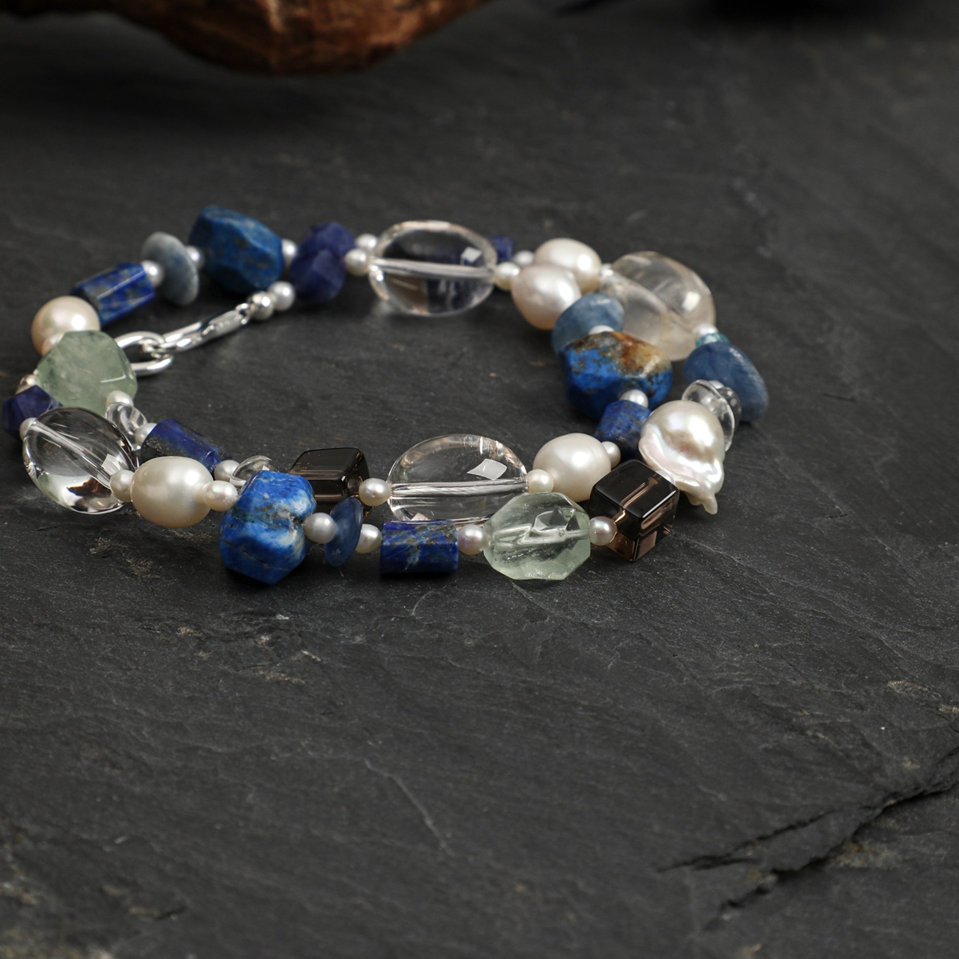 Lapis lazuli necklace with blue lapis beads, pearls, and clear quartz in a silver setting