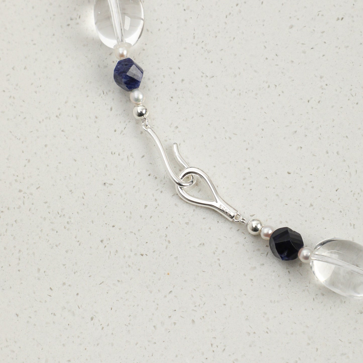 Lapis lazuli necklace clasp detail: blue bead segment with crystal and pearl accents