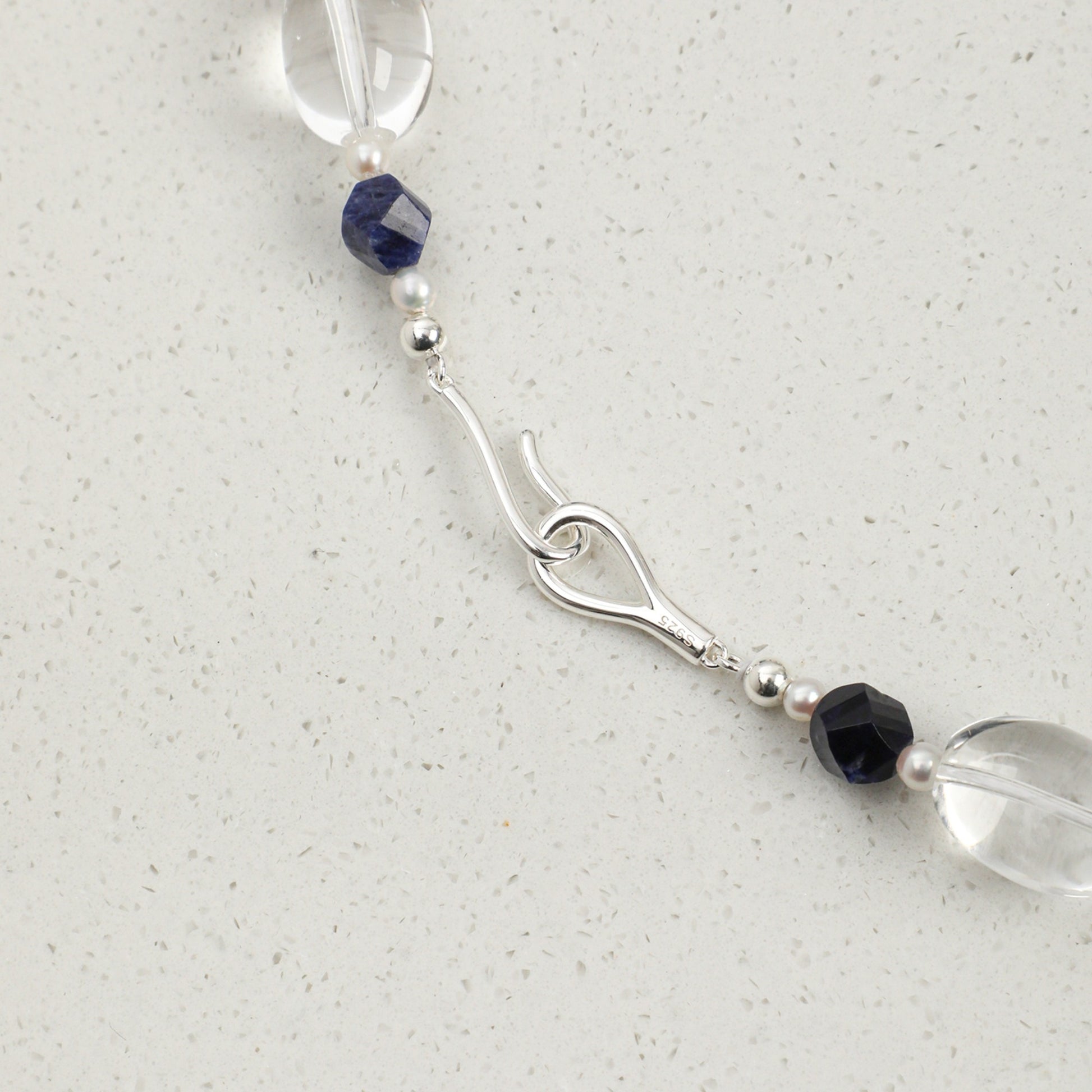 Lapis lazuli necklace clasp detail: blue bead segment with crystal and pearl accents