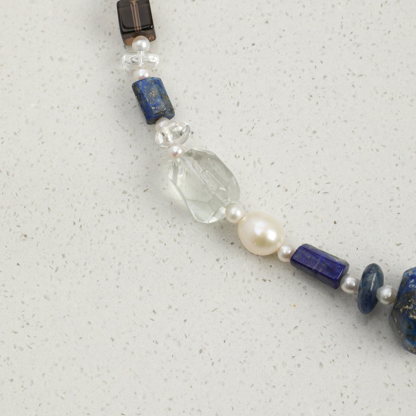 Lapis lazuli necklace detail: blue and pearl beads with clear faceted crystal and clasp