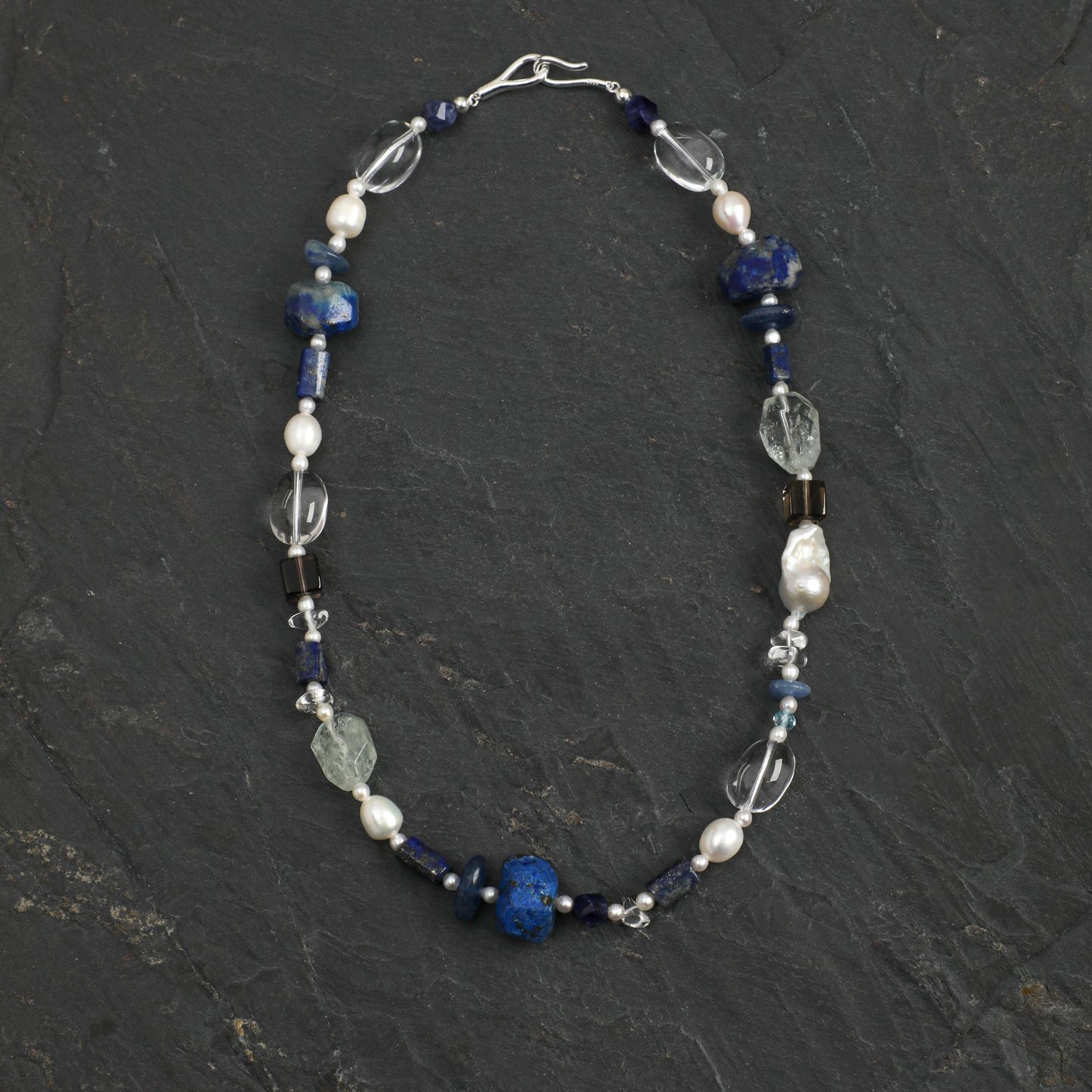Lapis lazuli necklace with blue beads, pearl accents, and clear crystal charms