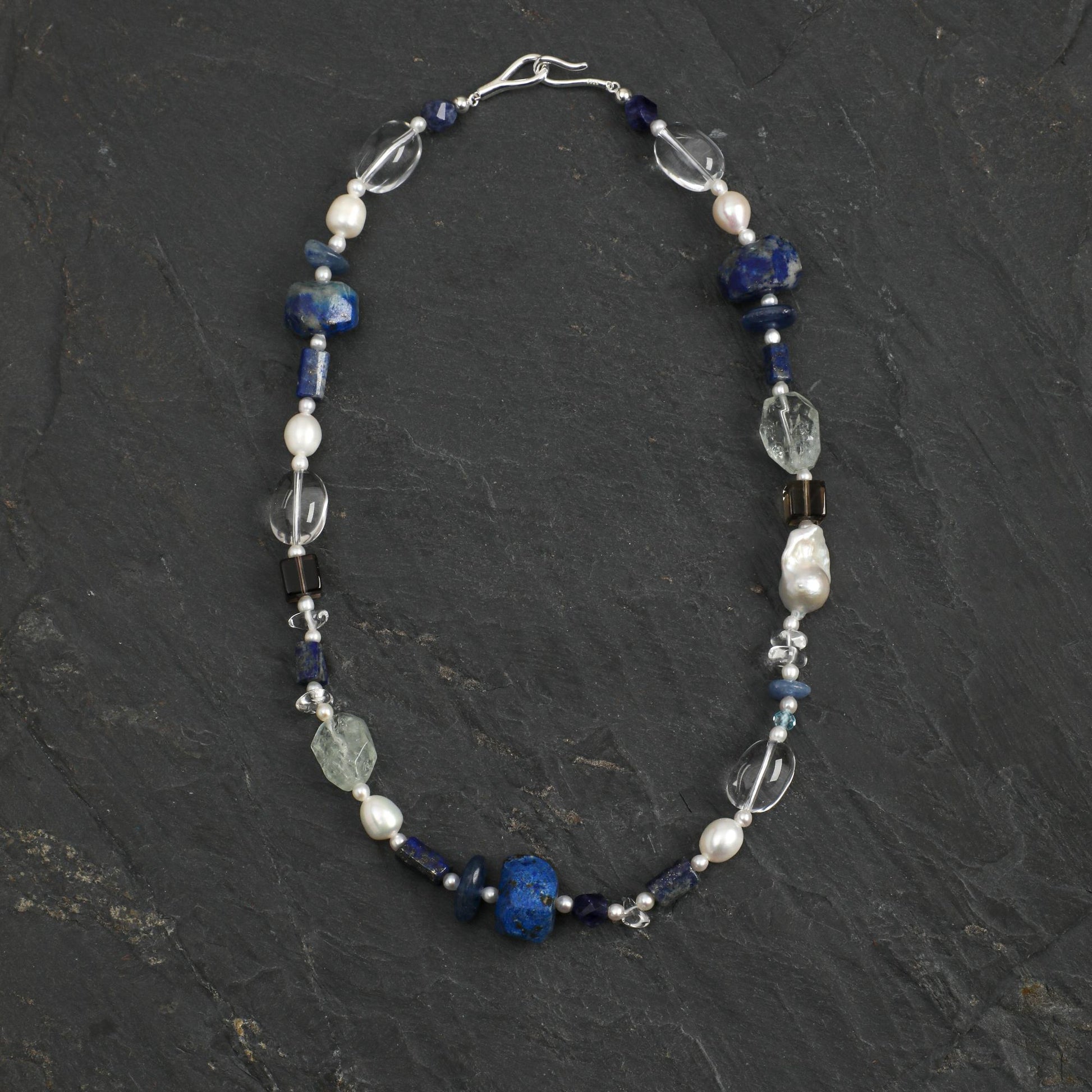 Lapis lazuli necklace with blue beads, pearl accents, and clear crystal charms