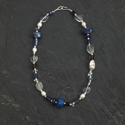 Lapis lazuli necklace with blue beads, pearl accents, and clear crystal charms