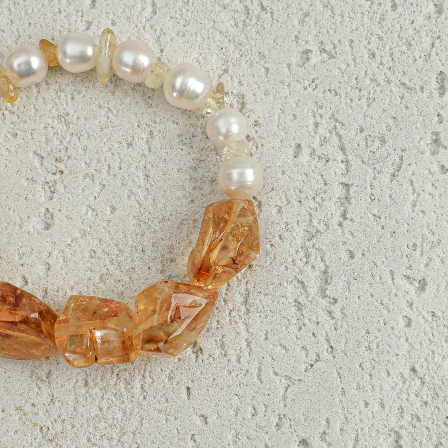 Citrine and pearl bracelet close-up with faceted amber stones and white pearl beads