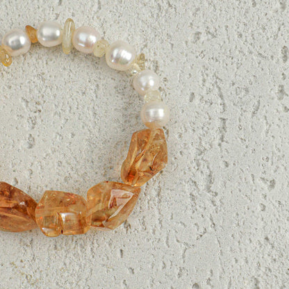Citrine and pearl bracelet close-up with faceted amber stones and white pearl beads