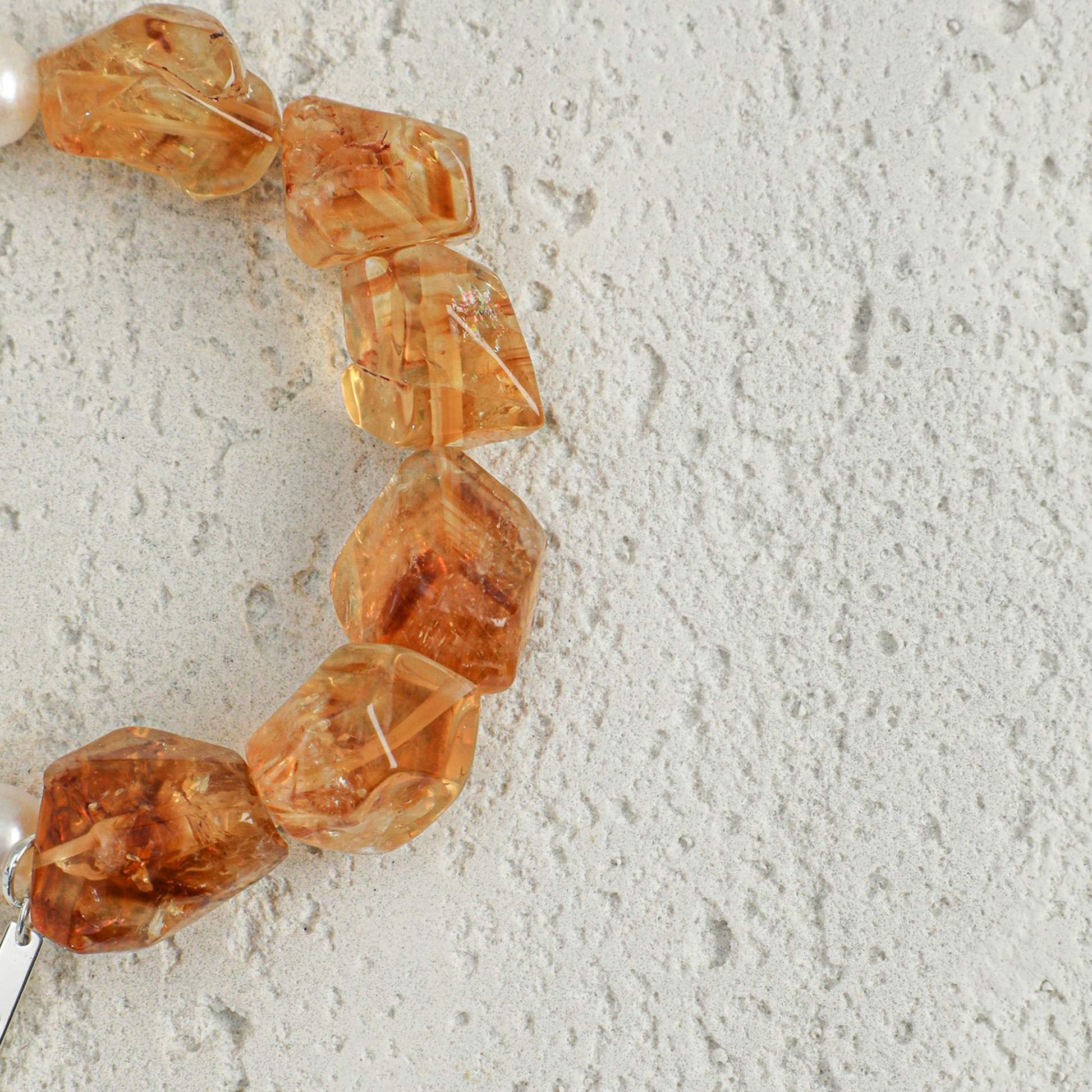 Amber citrine bead bracelet with white pearls and a visible metal clasp tag