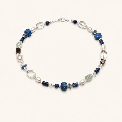 Lapis lazuli necklace with blue stone beads, clear quartz drops, and pearl accents