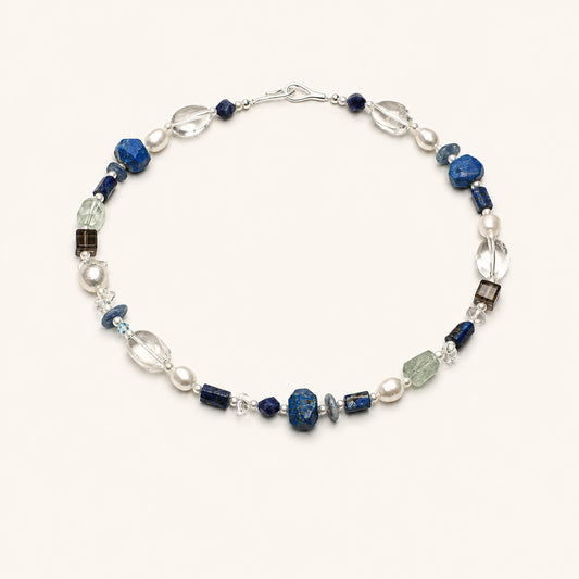 Lapis lazuli necklace with blue stone beads, clear quartz drops, and pearl accents