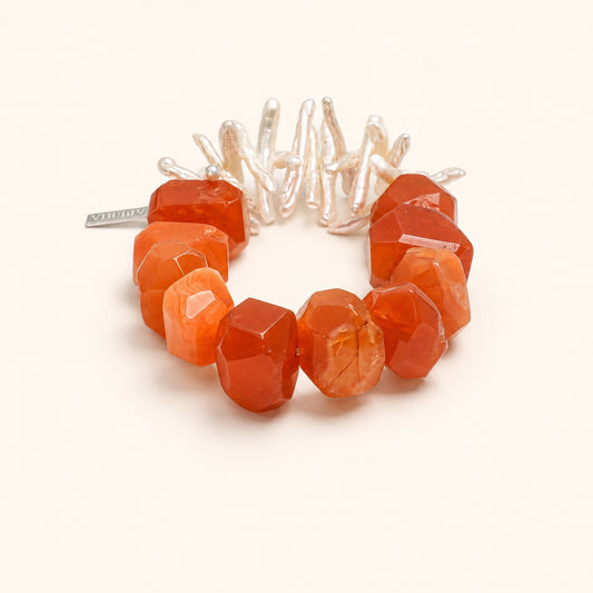 Orange-red agate bead bracelet with white pearl-like centerpiece and faceted stones