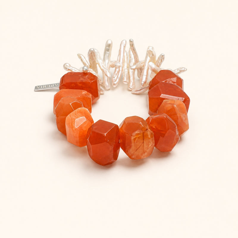 Orange-red agate bead bracelet with white pearl-like centerpiece and faceted stones