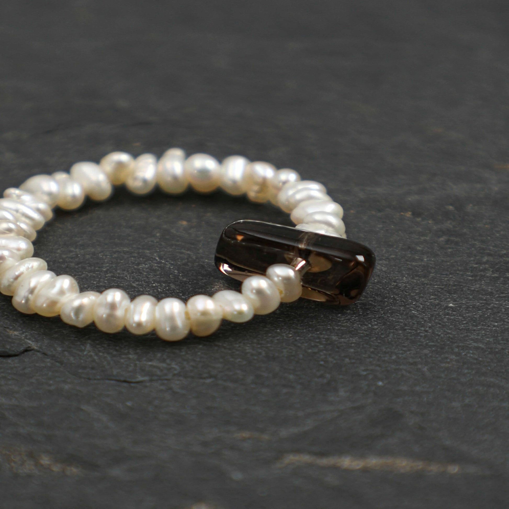 Pearl bead ring with dark oval gemstone insert, round beaded band