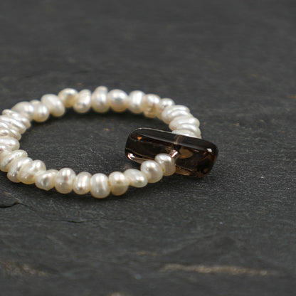 Pearl bead ring with dark oval gemstone insert, round beaded band