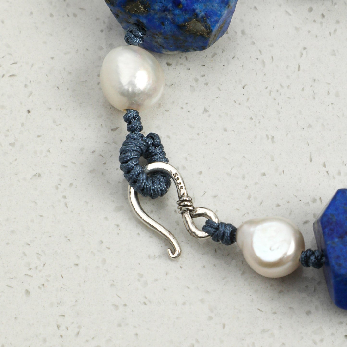 Lapis lazuli beaded bracelet with white pearls and blue cord, silver hook clasp