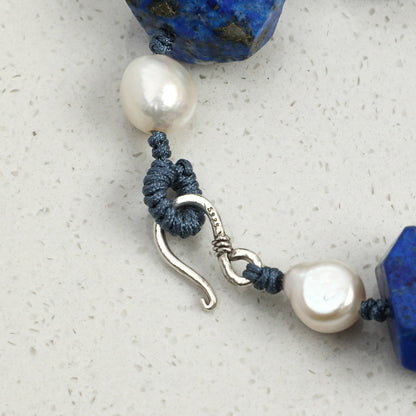 Lapis lazuli beaded bracelet with white pearls and blue cord, silver hook clasp