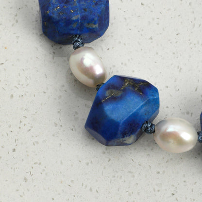 Lapis lazuli and pearl bracelet featuring faceted blue stones and cream pearls on cord