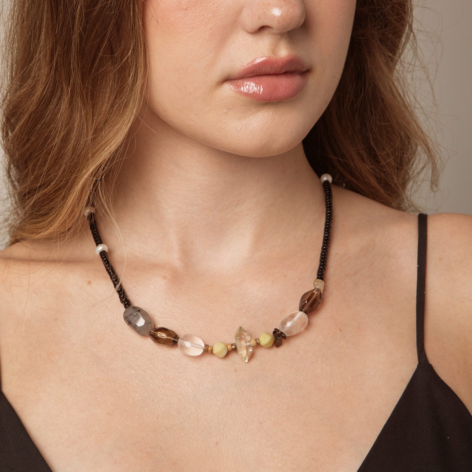 Model wearing black cord crystal necklace with clear, smoky grey and pearl-like bead details