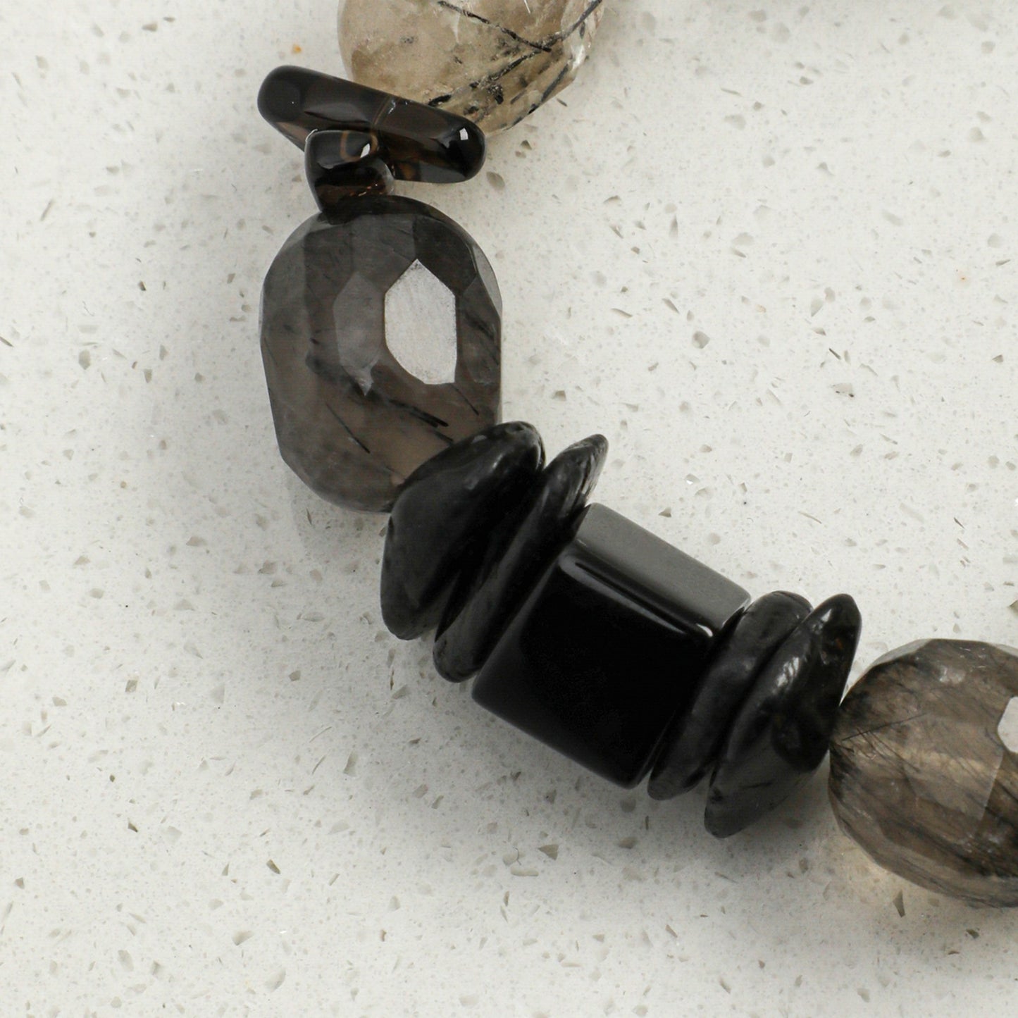 Crystal and pearl bracelet featuring dark gray stone beads and black spacer beads