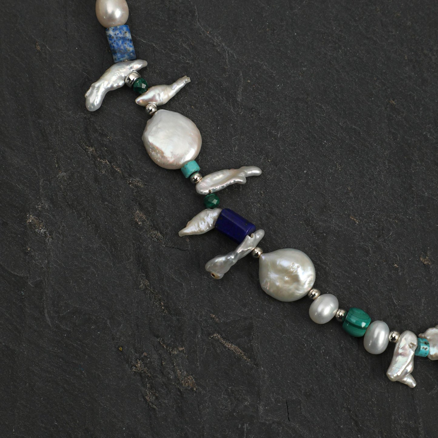 Baroque pearl necklace with silver bird charms, lapis blue bead, and teal-green stones