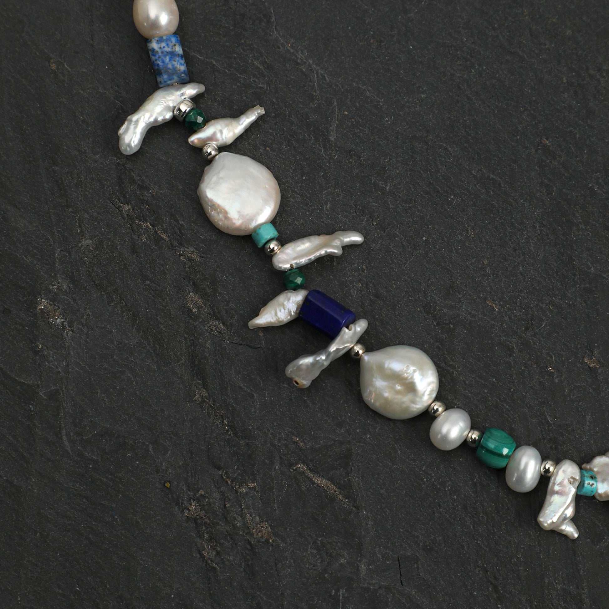Baroque pearl necklace with silver bird charms, lapis blue bead, and teal-green stones