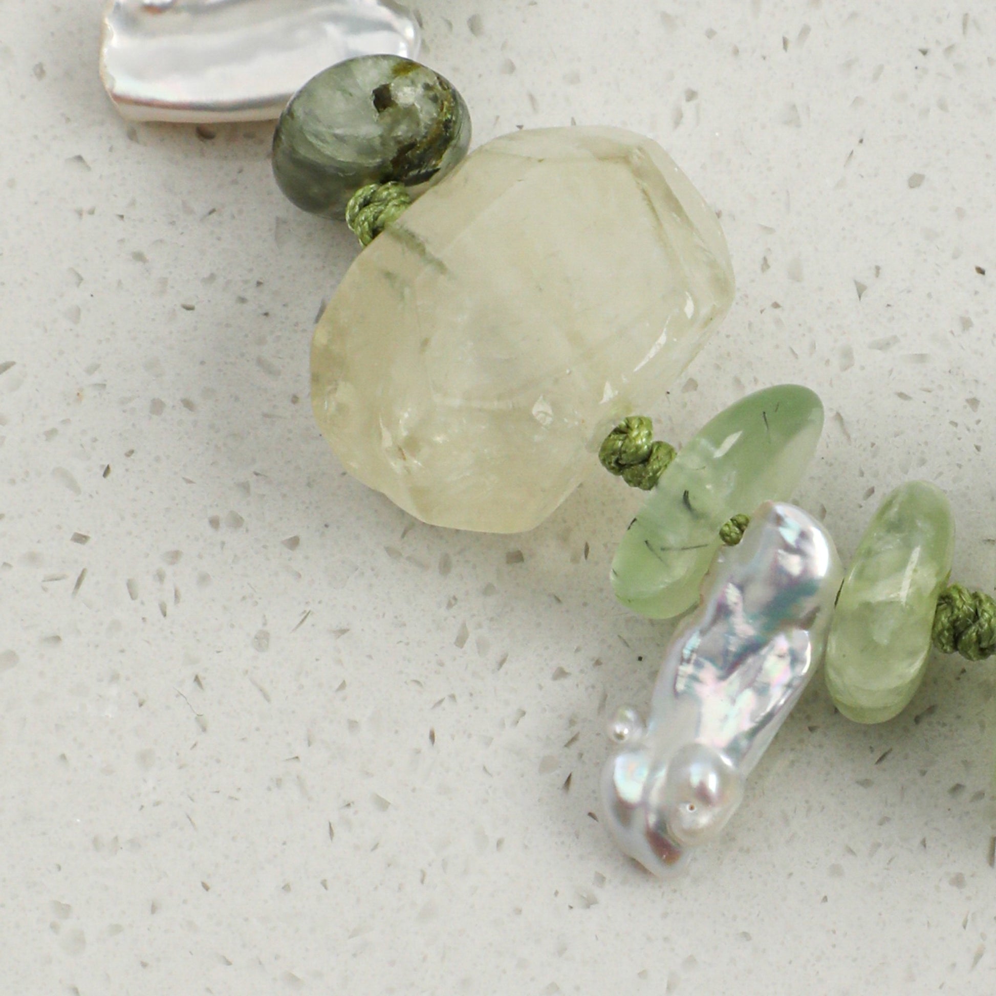 Citrine and prehnite bracelet close-up with white pearls, green beads, and silver accents