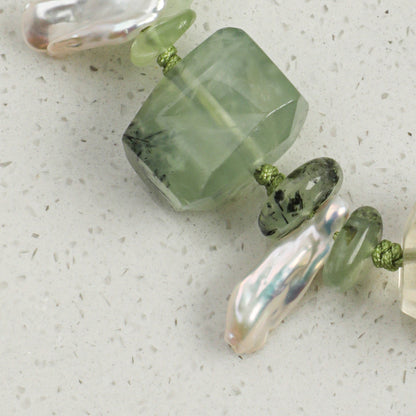 Green prehnite bracelet close-up with faceted stones, freshwater pearls, and silver links